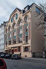 Blick von Südosten: Ansicht über Eck mit Blick in die Hofeinfahrt des Hauses Ainmillerstraße 22.