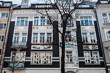 Untersicht der Straßenfassade über EG mit dem reichen Schmuck von Stuckornamenten.
