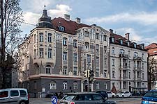 Blick von Südosten über Eck: Ansicht der Straßenfassade (Ostfassade) mit dem Erker an der südlichen Gebäudeecke und Blick in die Hofeinfahrt mit der Südfassade.