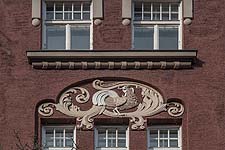Detail: dreifarbiges Stuckornament 'Auerhahn' an der Südfassade.
