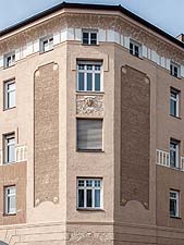 Ansicht der Gebäudeecke an der Plinganserstraße mit Fries, Stuckornamenten und Putzfeldern.
