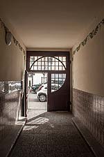 Blick aus der Hofdurchfahrt, gleichzeitig dem Hauseingang, zum Tor und der Straße. Auch die Durchfahrt ist mit gemalten vegetabilen Elementen geschückt.