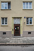 Hauseingang, mit Keramikfliesen gefasst und mit einem Relief über der Haustüre, in der Balmungstraße,